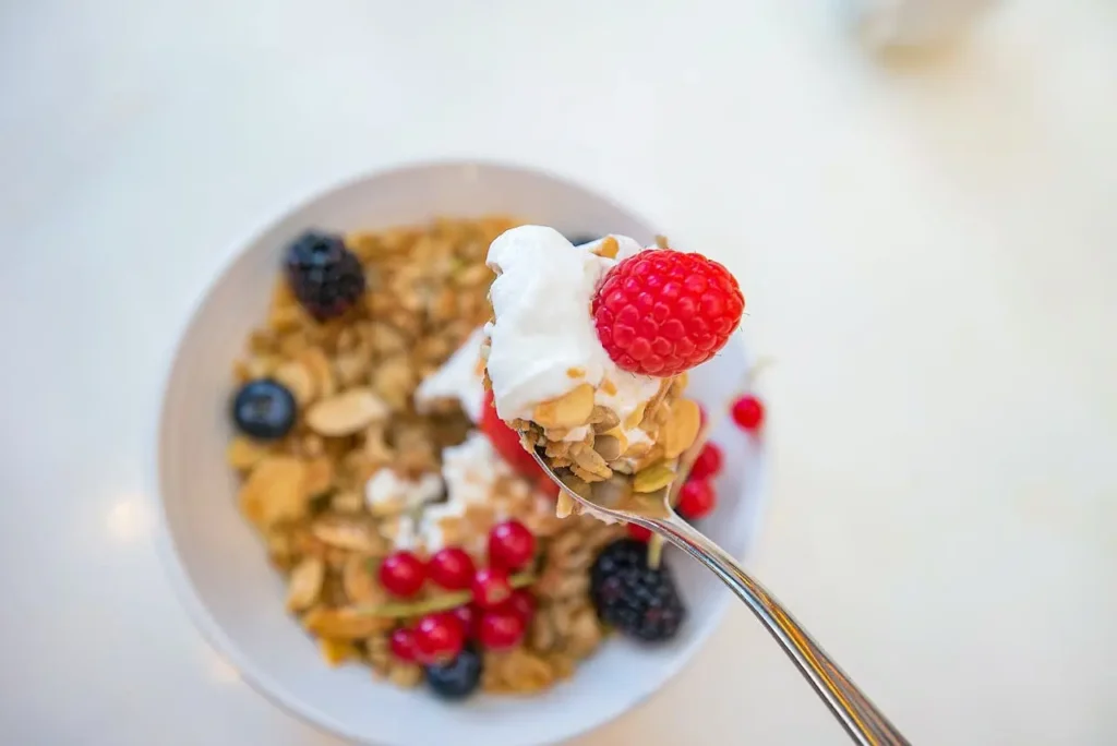 Cereales de desayuno saludables con yogur natural, frutos rojos y nueces