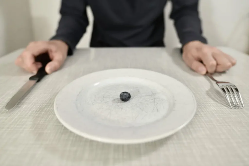 Por qué comer menos no te funciona: plato casi vacío con una sola fruta