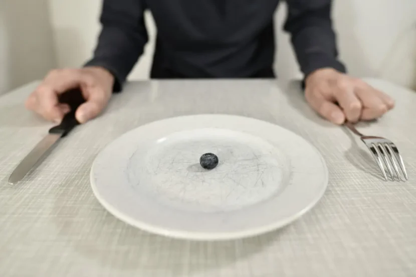 Por qué comer menos no te funciona: plato casi vacío con una sola fruta